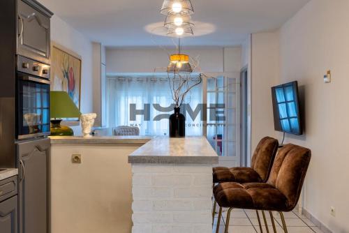 a kitchen with a counter and two chairs in a room at Family House in Caudry