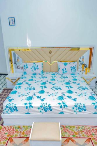 a bedroom with a bed with blue flowers on it at Le Wallo - Residence Sebi in Sébikhoutane