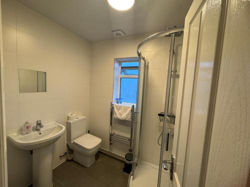 a bathroom with a toilet and a sink and a shower at London Heathrow Hayes Escape in South Ruislip Station