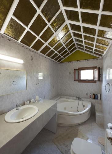 a bathroom with a tub and a toilet and a sink at Villa Aelia Kefalos-Private & Spacious with Pool in Kámpos