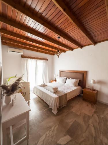 a bedroom with a large bed and a wooden ceiling at Villa Aelia Kefalos-Private & Spacious with Pool in Kámpos