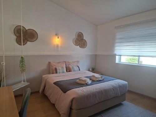 a bedroom with a bed with towels on it at Vila Glória Guesthouse in Lagos