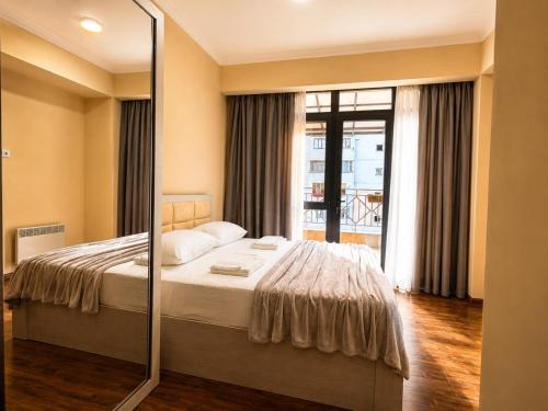 a bedroom with a bed and a mirror at Riverside Penthouse in Dilijan in Dilijan