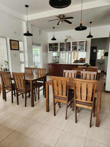 a dining room with a table and wooden chairs at Domus Florum Travellers Inn in Legazpi