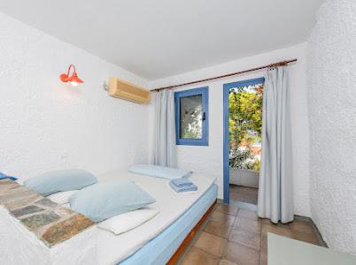 a bedroom with a bed and a window and a door at Rosys Little Village in Skala