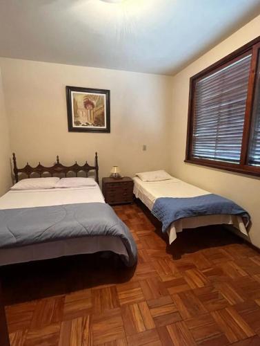 a bedroom with two beds and a window at Casa aconchegante in Teresópolis