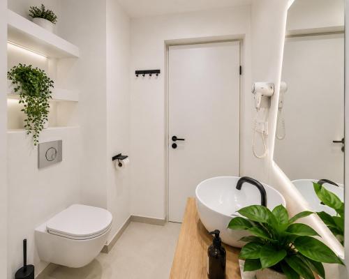 a bathroom with a white toilet and a sink at Metropole Apartments Romana Square in Bucharest