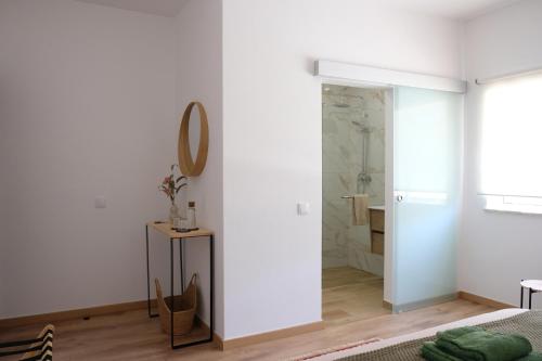 a white bathroom with a mirror and a shower at Vila Glória Guesthouse in Lagos