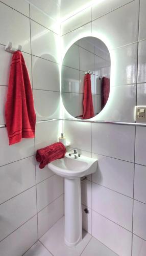 a white bathroom with a sink and a mirror at Apartamento EL PRADO de lujo in Cochabamba