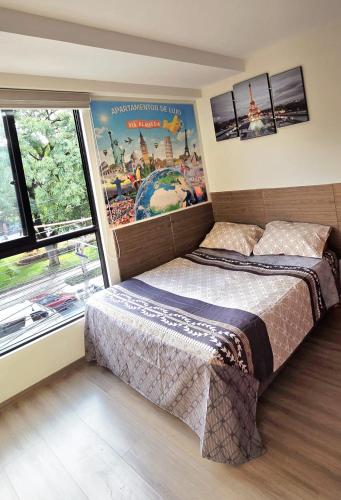 a bedroom with a bed and a poster on the wall at Apartamento EL PRADO de lujo in Cochabamba