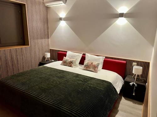 a bedroom with a large bed with two pillows at Casa Encosta da Caniçada in Vieira do Minho