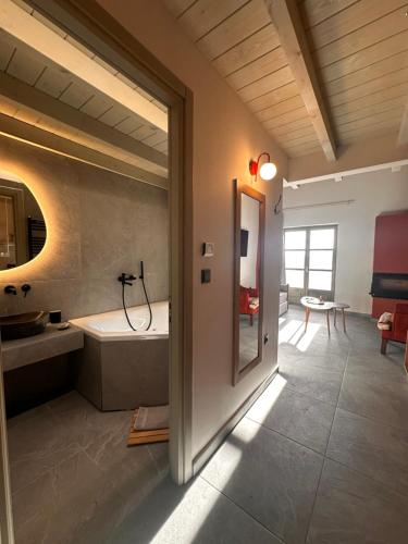 a bathroom with a tub and a sink and a mirror at Pirrion Villas in Ano Pedina