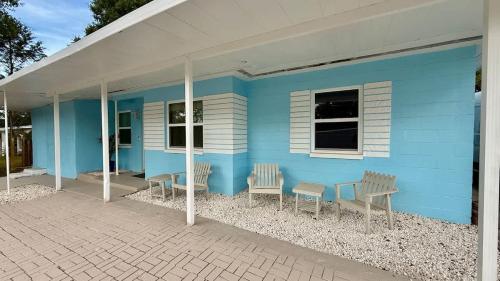 a blue house with chairs and a table outside at Charming Citrus in Inverness