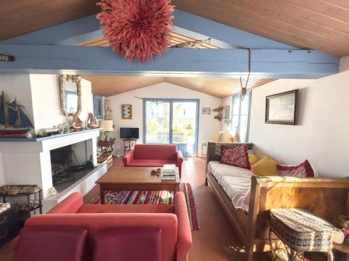 a living room with a couch and a table at Charmante maison front de mer avec jardin in La Guérinière