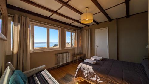 a bedroom with a bed and a large window at Bariloche Hostel in San Carlos de Bariloche