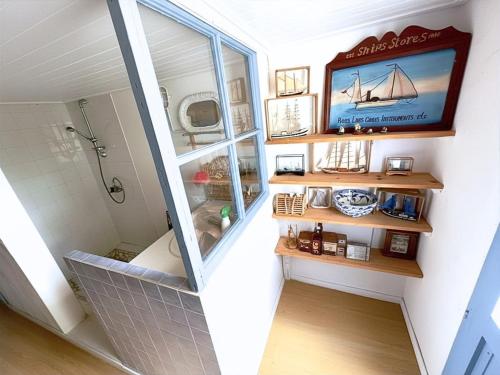 a bathroom with a window and a tv on a wall at Charmante maison front de mer avec jardin in La Guérinière