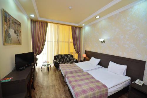 A bed or beds in a room at Yerevan Deluxe Hotel