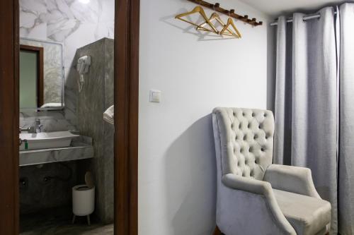 a bathroom with a white chair and a sink at Aylane Hotel in Nampula