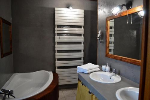 a bathroom with two sinks and a mirror at Le Marancènes in Laroque-Timbaut