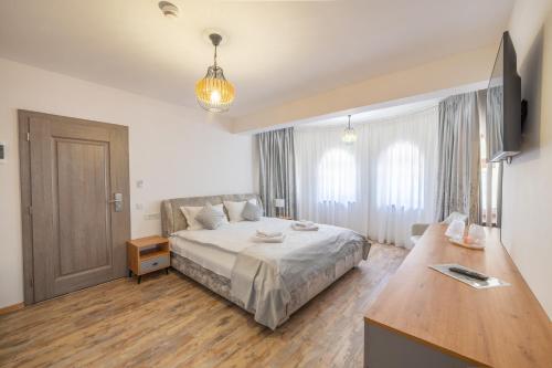 a bedroom with a bed and a desk in it at Pensiunea Seraris in Voineasa