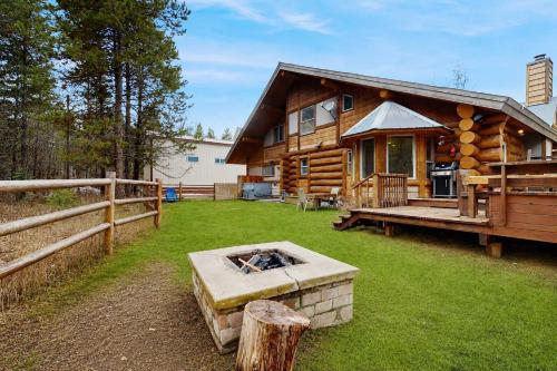 a log cabin with a fire pit in the yard at Pinedale Cabin in McCall