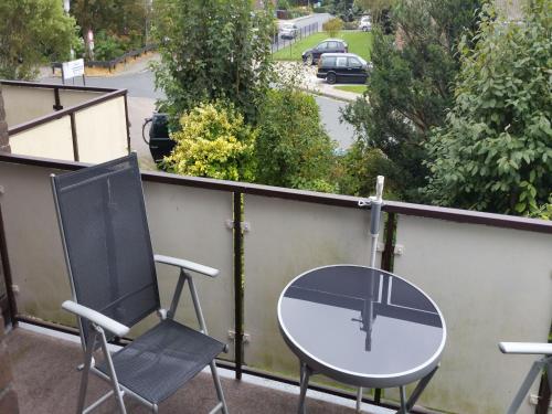 - Balcón con mesa y 2 sillas en Gästehaus Vogel, en Horumersiel