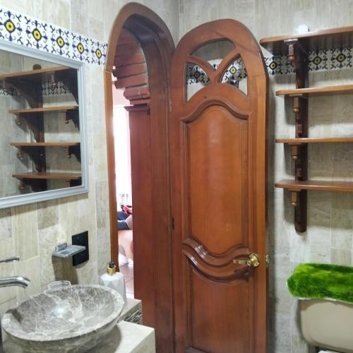 a bathroom with a wooden door and a sink at Villa Cholula in Cholula