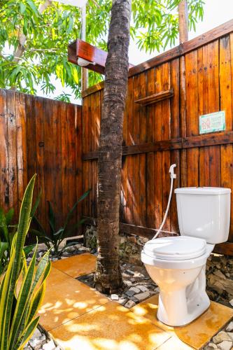 a toilet sitting in front of a wooden fence at Indiana Kite school and Hostel in Cumbuco