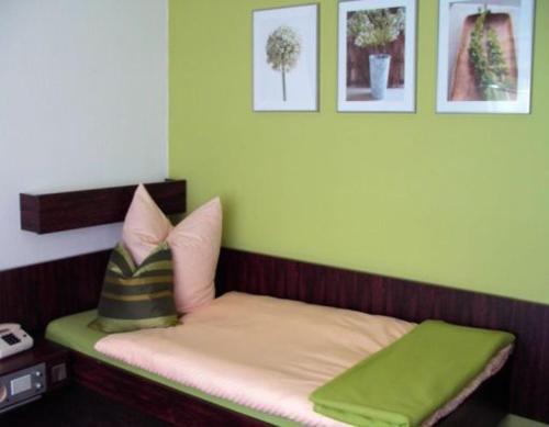 a small bed with two pillows in a room at Hotel Dietz in Bopfingen