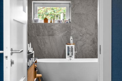 a bathroom with a white tub and a window at Cat-Friendly Archipelago Villa in Nacka