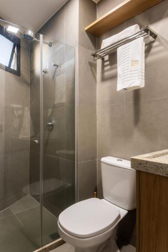 a bathroom with a toilet and a glass shower at Nomar 208 pe na areia na Praia dos carneiros in Tamandaré