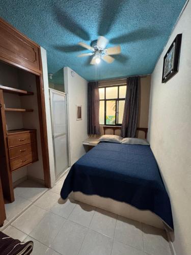 a bedroom with a bed with a blue ceiling at Hotel Los Arcos in Pénjamo