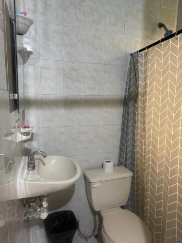 a bathroom with a toilet and a sink at Hotel Los Arcos in Pénjamo