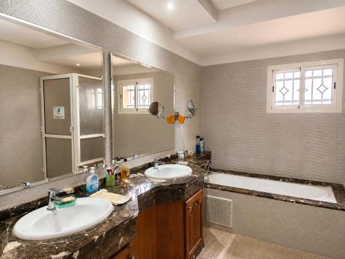 a bathroom with two sinks and a large mirror at Family fun farm - Évasion Nature - piscine et ferme in Berrechid