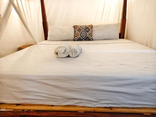 a bed with two towels and two pillows on it at Garden Level Studio in Mtwapa