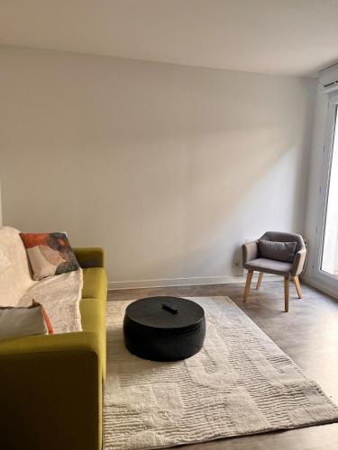 a living room with a yellow couch and a ottoman at La Parenthèse Calme in Tours