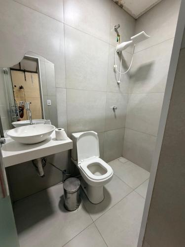 a bathroom with a toilet and a sink at Casa Maestro Tristão in Franca