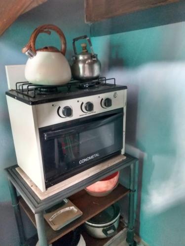 a stove with a tea kettle on top of it at El olivo apart in City Bell