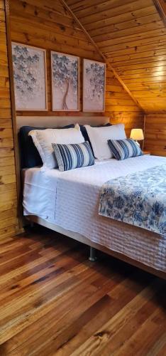 a bedroom with a bed in a wooden cabin at Chalé Vale das Montanhas in Timbe do Sul