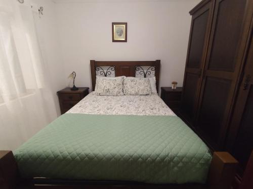 a bedroom with a bed with a green comforter at Retiro da Charneca in Fazendas de Almeirim