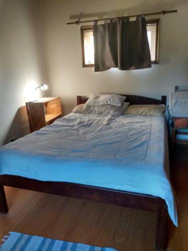 a bedroom with a large bed with blue sheets at El olivo apart in City Bell