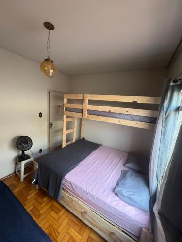 a bedroom with a bunk bed with purple sheets at Pousada Dois Irmãos in Uberaba
