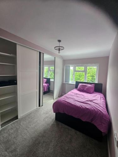 a bedroom with a purple bed and a mirror at Elim House in Birmingham