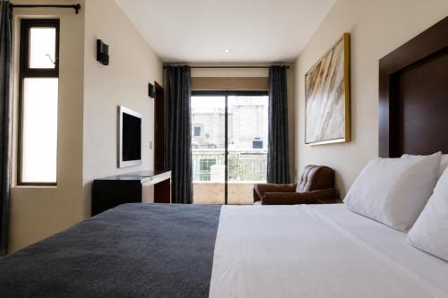 a hotel room with a bed and a chair and a window at Gold Palace Hotel in San Juan de los Lagos