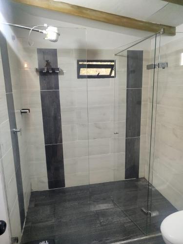 a shower with a glass door in a bathroom at Bosque Encantado Cabañas chalet in Guatapé