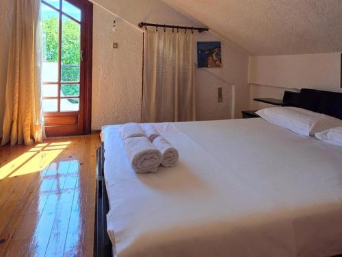 a bedroom with a large white bed with towels on it at KiteBay Villa in Rákhai
