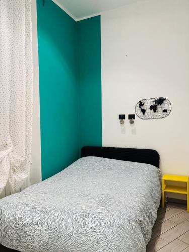 a bedroom with a green accent wall and a bed at Il filo di Claudia in Savona