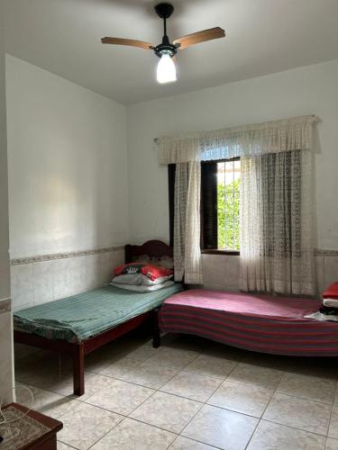 a room with two beds and a window at Casa Imponente Vila Atlântica - Beira Mar in Mongaguá