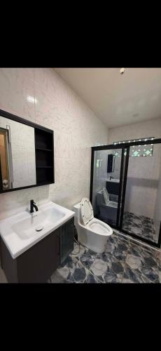 a bathroom with a sink and a toilet in it at Dorz Inn in Basdiot