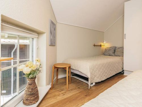a bedroom with a bed and a vase with flowers at 8 person holiday home in Bogense-By Traum in Bogense